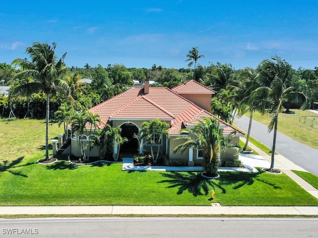 5667 Winkler Rd, Fort Myers, FL 33919 - mediterranean / spanish-style house with a tiled roof, a front yard, stucco siding, and a chimney