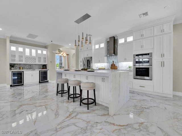 5667 Winkler Rd, Fort Myers, FL 33919 - kitchen with beverage cooler, wall chimney range hood, light marble finish floors, stainless steel double oven, and crown molding