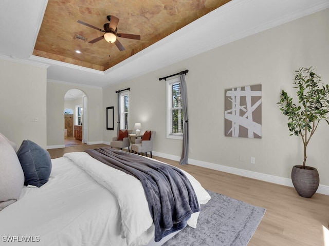 5667 Winkler Rd, Fort Myers, FL 33919 - bedroom featuring a raised ceiling, arched walkways, wood finished floors, baseboards, and ensuite bathroom