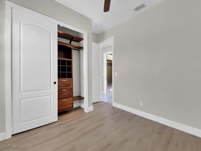 5667 Winkler Rd, Fort Myers, FL 33919 - unfurnished bedroom with light wood finished floors, baseboards, a closet, and a ceiling fan