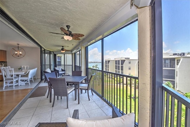 929 Collier Ct Unit B401, Marco Island, FL 34145 - sunroom / solarium with outdoor dining space, ceiling fan, a water view, and a chandelier