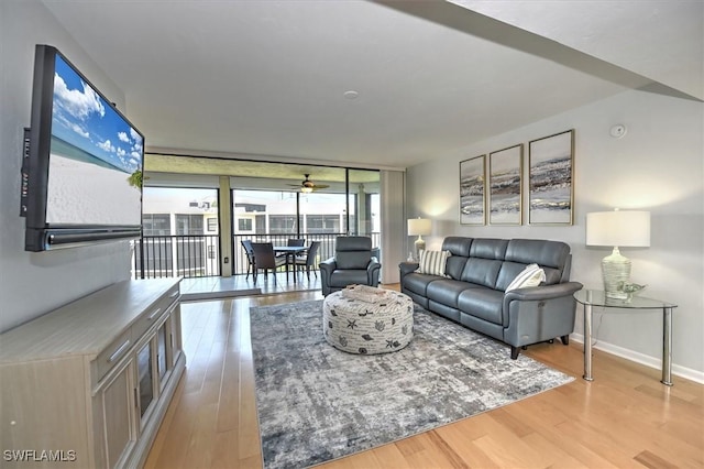 929 Collier Ct Unit B401, Marco Island, FL 34145 - living area featuring light wood-type flooring, baseboards, ceiling fan, and expansive windows