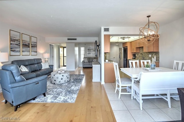 929 Collier Ct Unit B401, Marco Island, FL 34145 - living area featuring a chandelier and light wood-style flooring