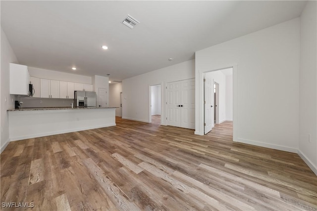 5205/5207 26th St SW, Lehigh Acres, FL 33973 - unfurnished living room featuring light wood finished floors, baseboards, and recessed lighting