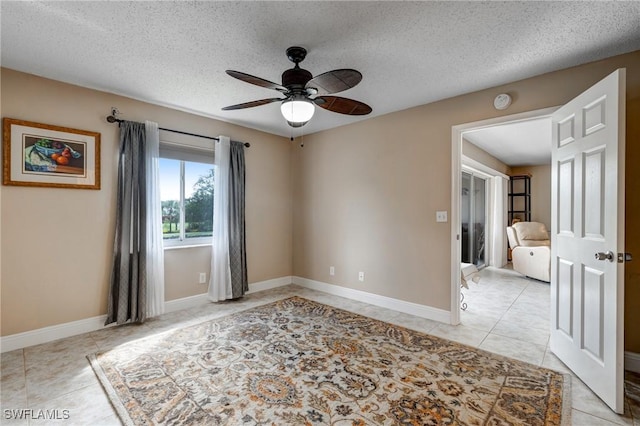 7065 Dennis Cir Unit F204, Naples, FL 34104 - tiled empty room featuring ceiling fan, a textured ceiling, and baseboards