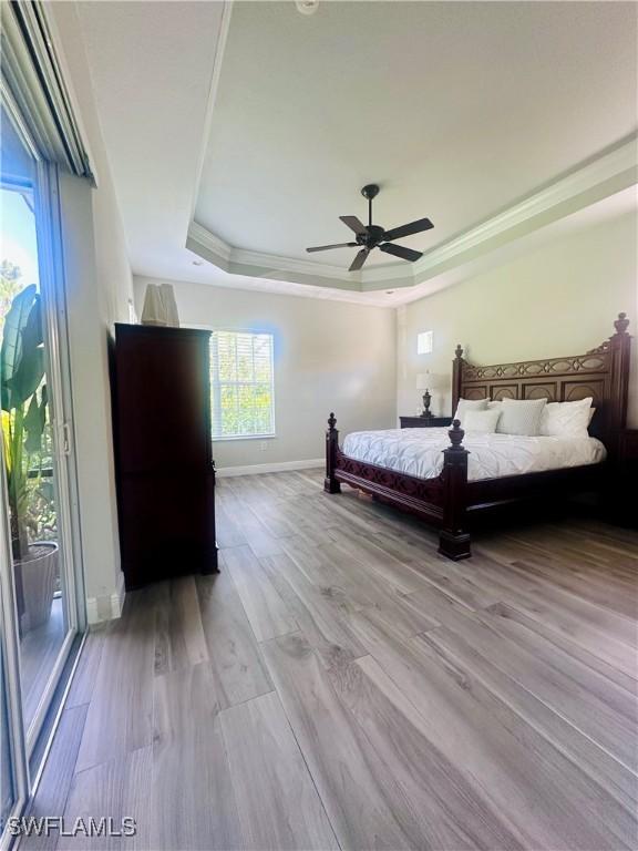 5489 Whispering Willow Way, Fort Myers, FL 33908 - bedroom with a raised ceiling, crown molding, baseboards, light wood finished floors, and ceiling fan