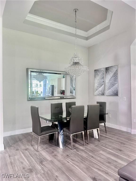 5489 Whispering Willow Way, Fort Myers, FL 33908 - dining area featuring a tray ceiling, wood finished floors, ornamental molding, a chandelier, and baseboards