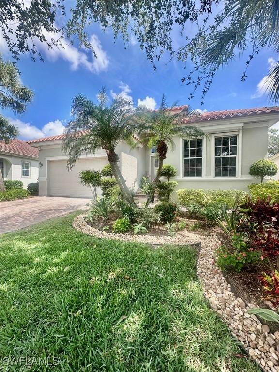 5489 Whispering Willow Way, Fort Myers, FL 33908 - view of front facade with stucco siding, a garage, driveway, and a tiled roof