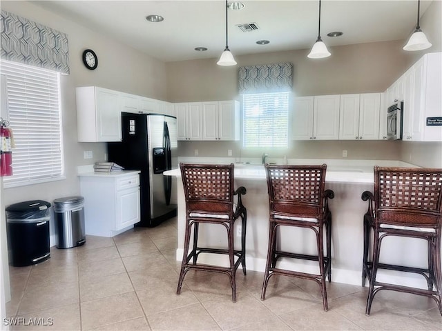 5489 Whispering Willow Way, Fort Myers, FL 33908 - kitchen featuring stainless steel appliances, a breakfast bar area, light countertops, and white cabinets