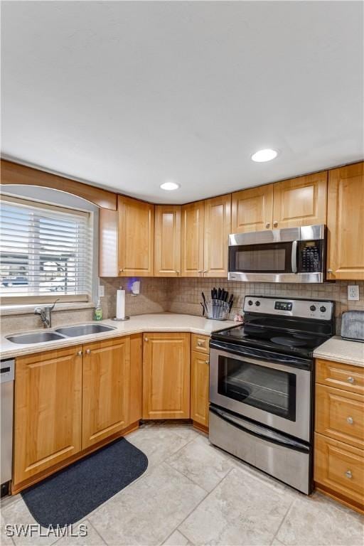 2100 Barkeley Ln Unit 1, Fort Myers, FL 33907 - kitchen featuring stainless steel appliances, a sink, tasteful backsplash, and light countertops