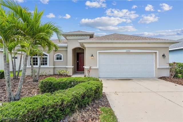 12642 Cara Cara Loop, Bradenton, FL 34212 - view of front of house with stucco siding, concrete driveway, an attached garage, and a shingled roof