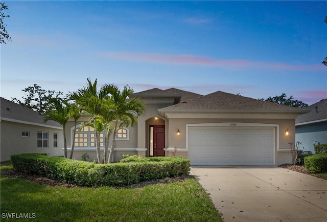 12642 Cara Cara Loop, Bradenton, FL 34212 - view of front of property with driveway, a garage, stucco siding, and roof with shingles