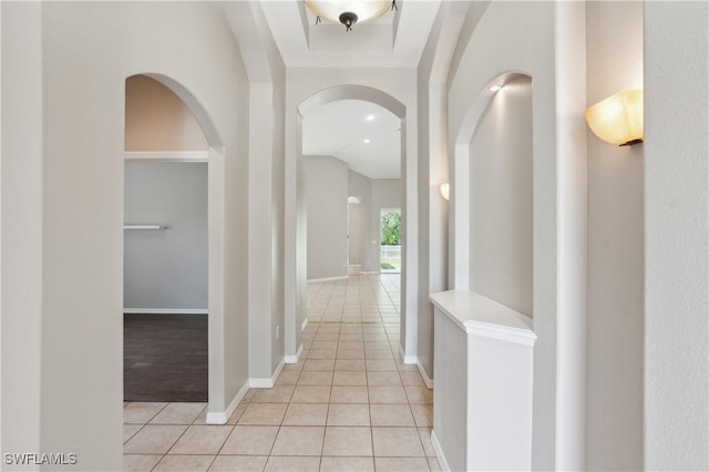 12642 Cara Cara Loop, Bradenton, FL 34212 - hall with arched walkways, light tile patterned floors, baseboards, and lofted ceiling