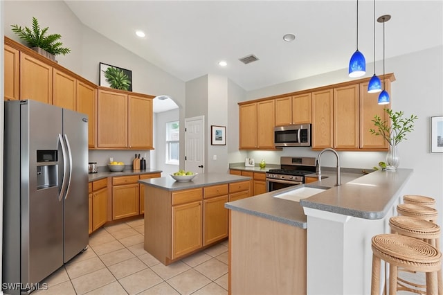 12642 Cara Cara Loop, Bradenton, FL 34212 - kitchen with stainless steel appliances, a sink, lofted ceiling, light tile patterned flooring, and arched walkways