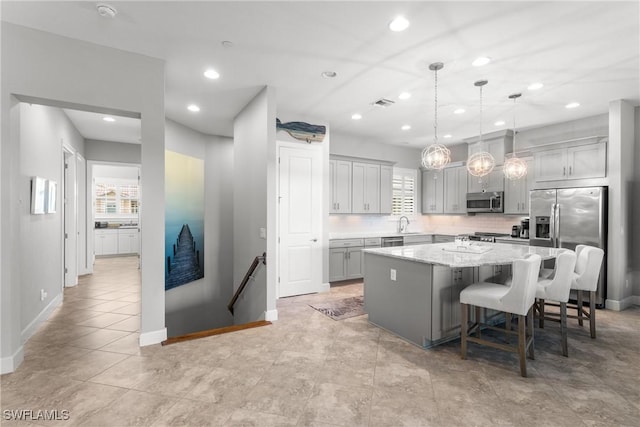 8761 Bellano Ct Unit 202, Naples, FL 34119 - kitchen featuring appliances with stainless steel finishes, a kitchen island, baseboards, recessed lighting, and decorative light fixtures