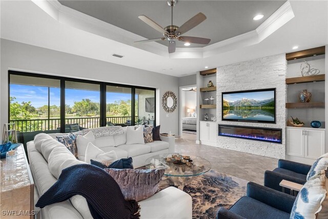 8761 Bellano Ct Unit 202, Naples, FL 34119 - living area with ornamental molding, built in shelves, a tray ceiling, a ceiling fan, and recessed lighting