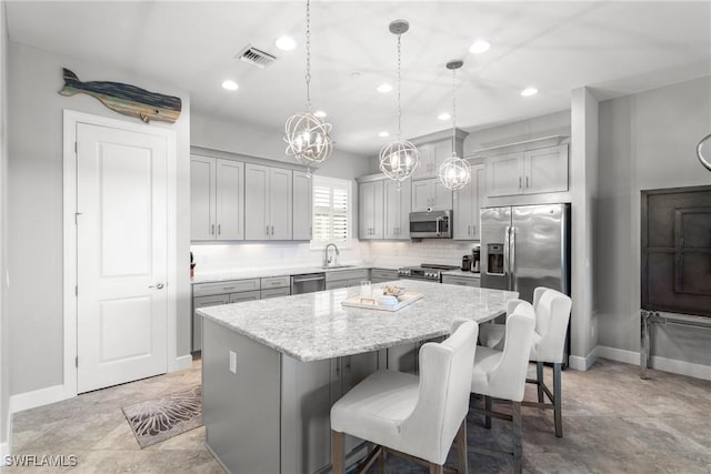 8761 Bellano Ct Unit 202, Naples, FL 34119 - kitchen featuring stainless steel appliances, a center island, recessed lighting, a sink, and a breakfast bar area