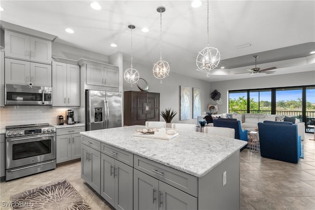 8761 Bellano Ct Unit 202, Naples, FL 34119 - kitchen with stainless steel appliances, gray cabinetry, backsplash, recessed lighting, and a center island