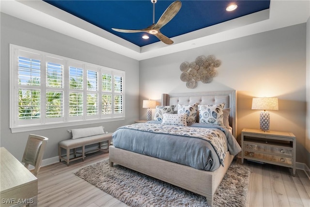 8761 Bellano Ct Unit 202, Naples, FL 34119 - bedroom with a raised ceiling, wood finished floors, baseboards, a ceiling fan, and recessed lighting