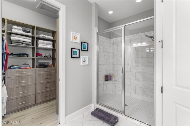 8761 Bellano Ct Unit 202, Naples, FL 34119 - bathroom featuring baseboards, a shower stall, a spacious closet, recessed lighting, and marble finish floors