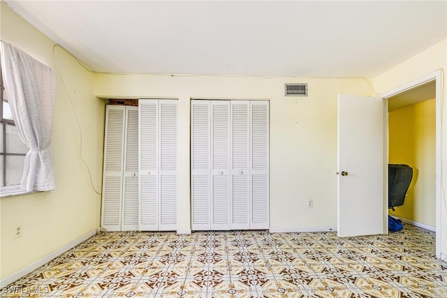 4900 Biscayne Dr Unit 14, Naples, FL 34112 - unfurnished bedroom with multiple closets, tile patterned floors, and baseboards