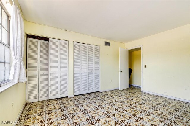 4900 Biscayne Dr Unit 14, Naples, FL 34112 - unfurnished bedroom featuring multiple closets, tile patterned floors, and baseboards