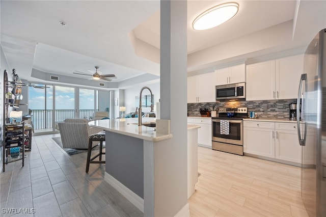 2797 1st St Unit 803, Fort Myers, FL 33916 - kitchen featuring appliances with stainless steel finishes, a raised ceiling, backsplash, a sink, and open floor plan
