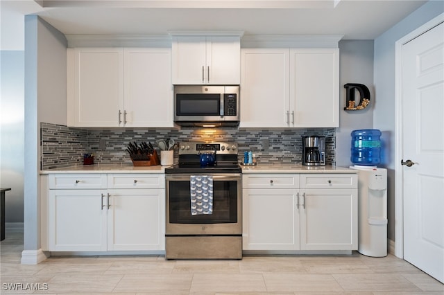 2797 1st St Unit 803, Fort Myers, FL 33916 - kitchen featuring appliances with stainless steel finishes, light countertops, white cabinets, and decorative backsplash