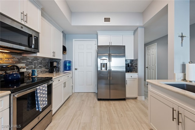 2797 1st St Unit 803, Fort Myers, FL 33916 - kitchen featuring appliances with stainless steel finishes, tasteful backsplash, light countertops, and light wood-style flooring
