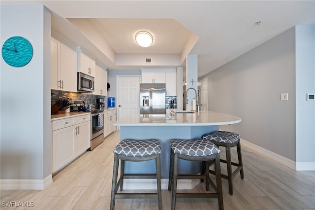 2797 1st St Unit 803, Fort Myers, FL 33916 - kitchen with appliances with stainless steel finishes, baseboards, a breakfast bar area, and light wood-type flooring