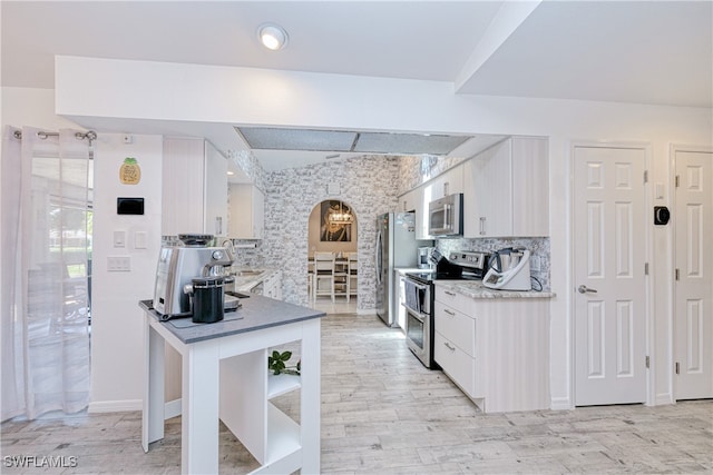 25379 Paladin Ln, Punta Gorda, FL 33983 - kitchen featuring stainless steel appliances, white cabinetry, backsplash, and healthy amount of natural light