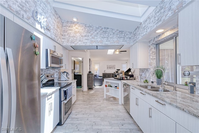 25379 Paladin Ln, Punta Gorda, FL 33983 - kitchen featuring appliances with stainless steel finishes, a sink, tasteful backsplash, white cabinets, and light stone counters