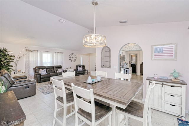 25379 Paladin Ln, Punta Gorda, FL 33983 - dining space with light tile patterned floors, vaulted ceiling, arched walkways, and a chandelier
