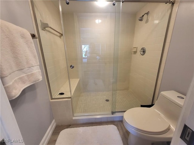 11460 Caravel Cir Unit 5016, Fort Myers, FL 33908 - full bathroom with a stall shower, toilet, baseboards, and wood finished floors