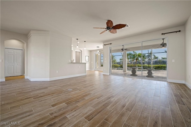 1069 SW 57th St, Cape Coral, FL 33914 - unfurnished living room with wood finished floors, a ceiling fan, and arched walkways