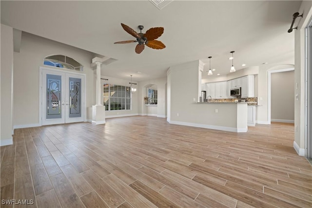 1069 SW 57th St, Cape Coral, FL 33914 - unfurnished living room with ceiling fan, light wood-type flooring, recessed lighting, arched walkways, and french doors