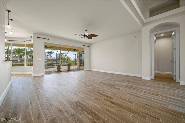 1069 SW 57th St, Cape Coral, FL 33914 - empty room with a ceiling fan, wood finished floors, and arched walkways