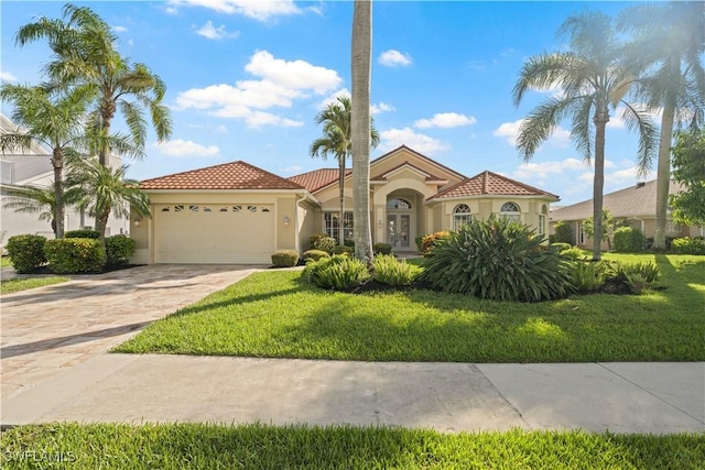 1069 SW 57th St, Cape Coral, FL 33914 - mediterranean / spanish-style home with an attached garage, stucco siding, a front lawn, a tiled roof, and concrete driveway