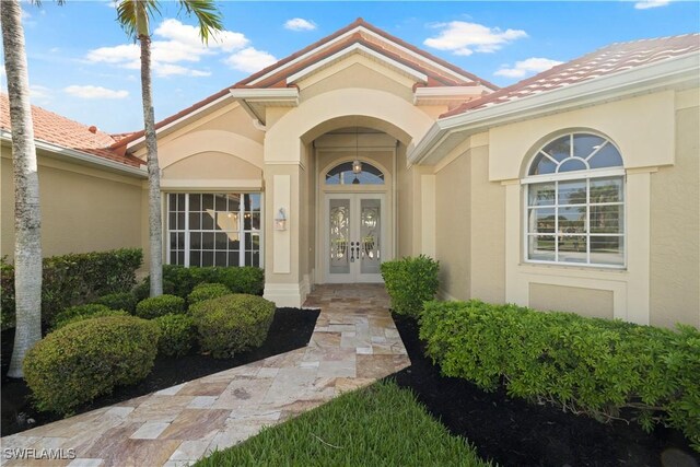 1069 SW 57th St, Cape Coral, FL 33914 - view of exterior entry with french doors and stucco siding