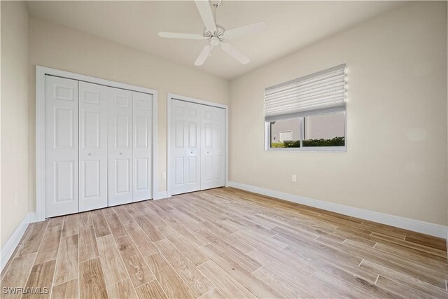 1069 SW 57th St, Cape Coral, FL 33914 - unfurnished bedroom featuring multiple closets, wood finished floors, and ceiling fan