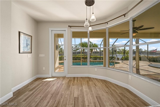 1069 SW 57th St, Cape Coral, FL 33914 - unfurnished dining area featuring a sunroom, wood finished floors, and a ceiling fan