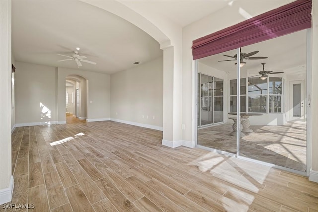1069 SW 57th St, Cape Coral, FL 33914 - empty room with arched walkways, ceiling fan, and wood finished floors