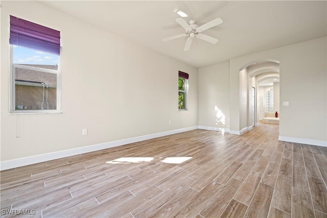 1069 SW 57th St, Cape Coral, FL 33914 - spare room featuring arched walkways, wood finished floors, and a ceiling fan