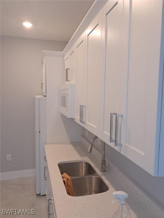 3016 6th St W, Lehigh Acres, FL 33971 - kitchen featuring a sink, white appliances, white cabinetry, light stone counters, and recessed lighting
