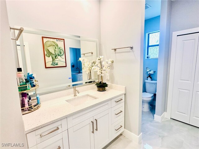 3016 6th St W, Lehigh Acres, FL 33971 - bathroom with toilet, vanity, and baseboards