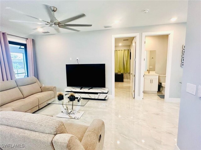 3016 6th St W, Lehigh Acres, FL 33971 - living room with a ceiling fan, light marble finish flooring, and baseboards