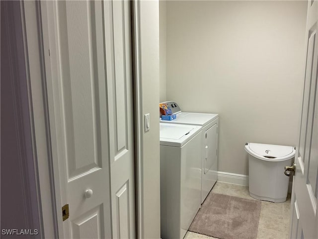 1516 SW 50th St Unit 104, Cape Coral, FL 33914 - laundry room featuring washing machine and clothes dryer, light tile patterned floors, and baseboards