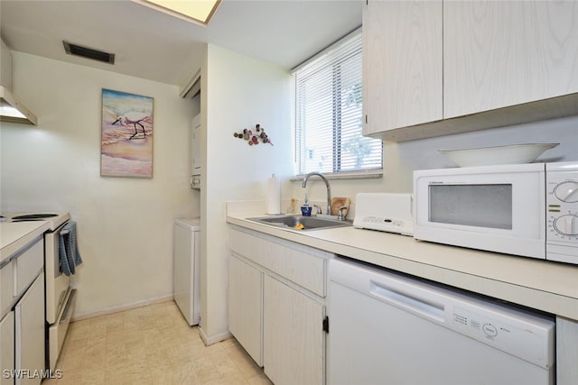3350 Alouette Cir Unit 1, Fort Myers, FL 33907 - kitchen featuring white appliances, a sink, light countertops, baseboards, and estacked washer and dryer