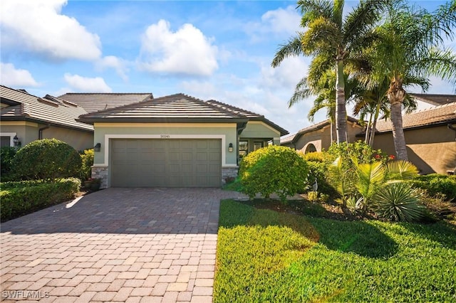 20245 Corkscrew Shores Blvd, Estero, FL 33928 - view of front of property featuring decorative driveway, an attached garage, stucco siding, and stone siding