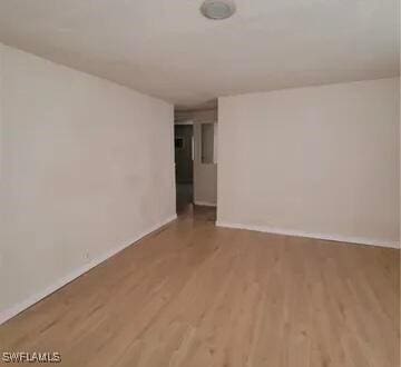 unfurnished room featuring wood finished floors and baseboards